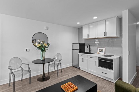 a kitchen with white cabinets and a table with chairs
